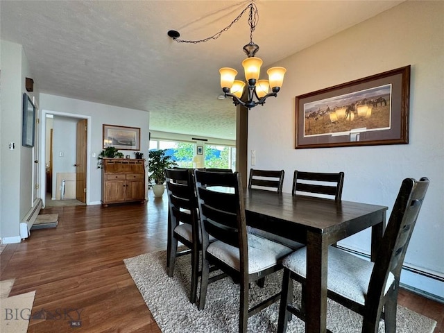 205 E Chinook St, Livingston, MT 59047 - dining area with a chandelier, dark wood-style floors, baseboards, and a baseboard heating unit