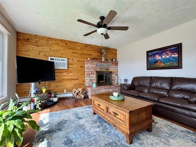 205 E Chinook St, Livingston, MT 59047 - living room featuring wood walls, ceiling fan, wood finished floors, a fireplace, and a wall mounted AC