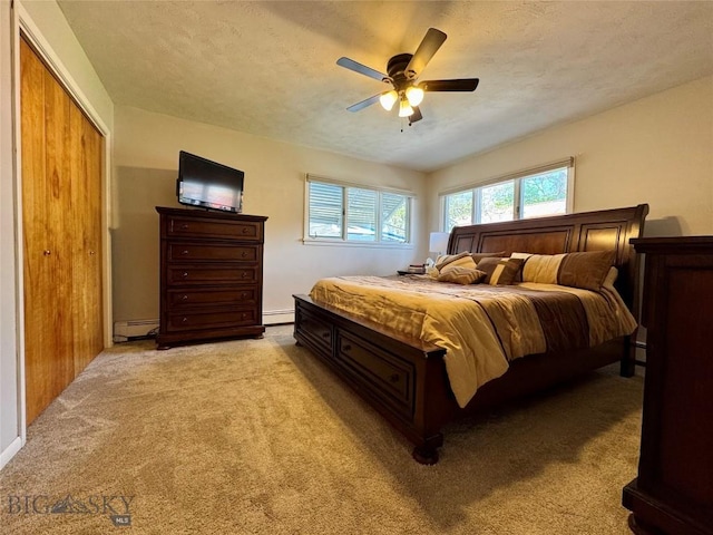 205 E Chinook St, Livingston, MT 59047 - bedroom with baseboard heating, light carpet, a baseboard radiator, ceiling fan, and a closet