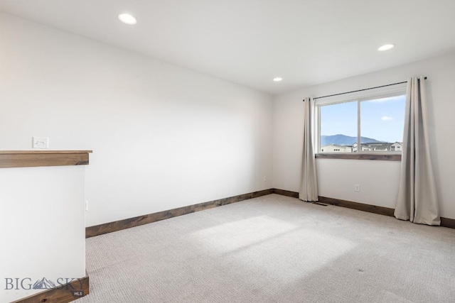 carpeted spare room featuring baseboards and recessed lighting