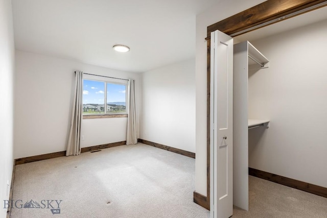 unfurnished bedroom with light colored carpet and baseboards
