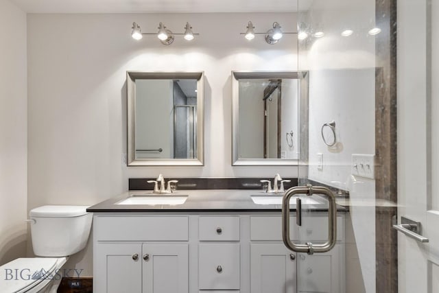 bathroom with toilet and double vanity