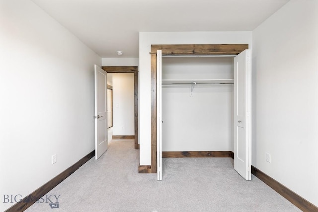 unfurnished bedroom featuring carpet flooring, a closet, and baseboards