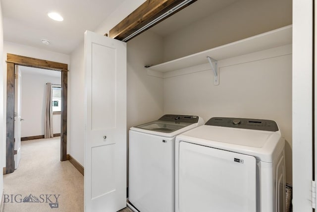 clothes washing area featuring washer and clothes dryer, light colored carpet, baseboards, and recessed lighting