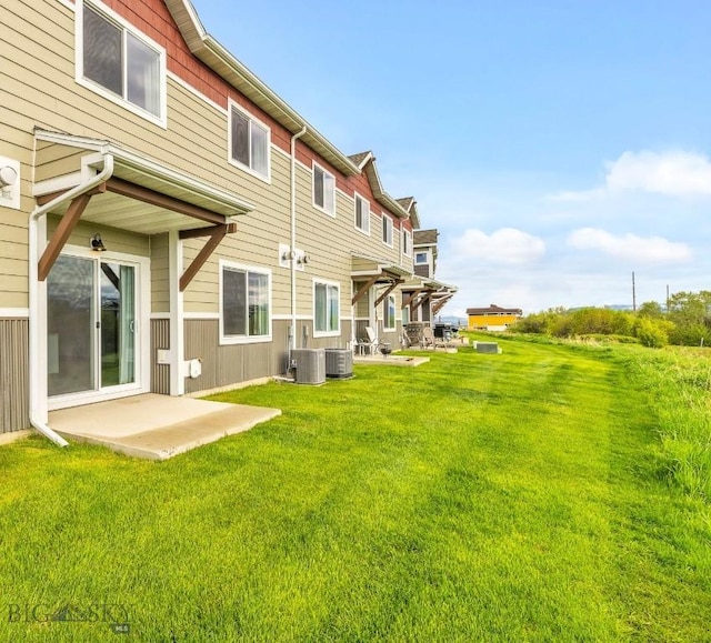 back of property featuring cooling unit and a lawn