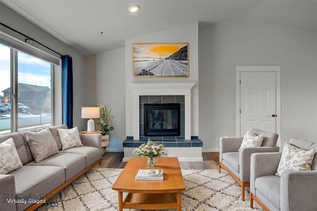 1510 Ingomar Blvd, Belgrade, MT 59714 - living area with lofted ceiling, wood finished floors, a tiled fireplace, baseboards, and recessed lighting