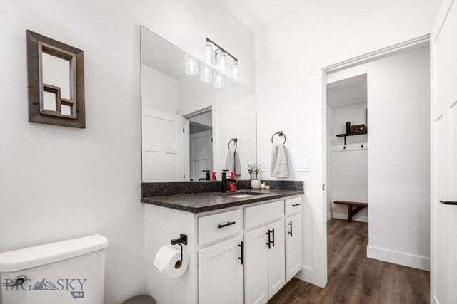 1506 Wild Bill Way, Belgrade, MT 59714 - bathroom featuring wood finished floors, toilet, vanity, and baseboards