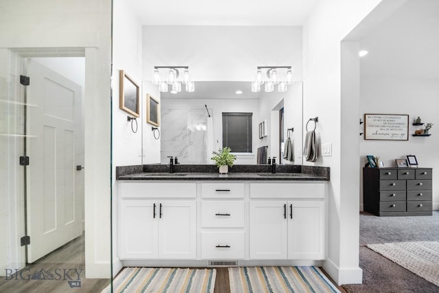 1506 Wild Bill Way, Belgrade, MT 59714 - bathroom with double vanity, a shower, baseboards, recessed lighting, and a chandelier