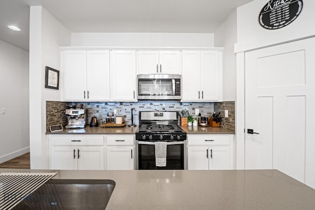 1506 Wild Bill Way, Belgrade, MT 59714 - kitchen with appliances with stainless steel finishes, dark countertops, tasteful backsplash, and white cabinets