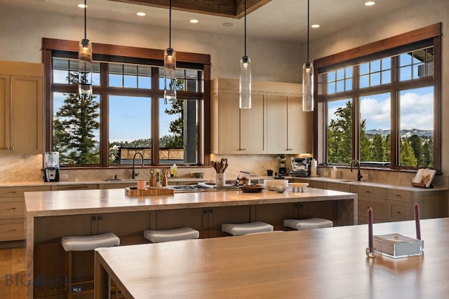 1220 Green Valley Way, Bozeman, MT 59715 - kitchen featuring a kitchen island, a sink, decorative backsplash, recessed lighting, and a breakfast bar