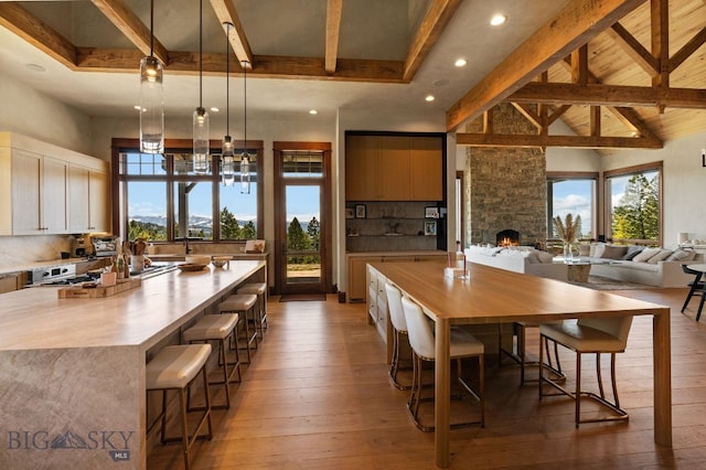 1220 Green Valley Way, Bozeman, MT 59715 - dining room with beam ceiling, light wood-style floors, recessed lighting, a fireplace, and plenty of natural light
