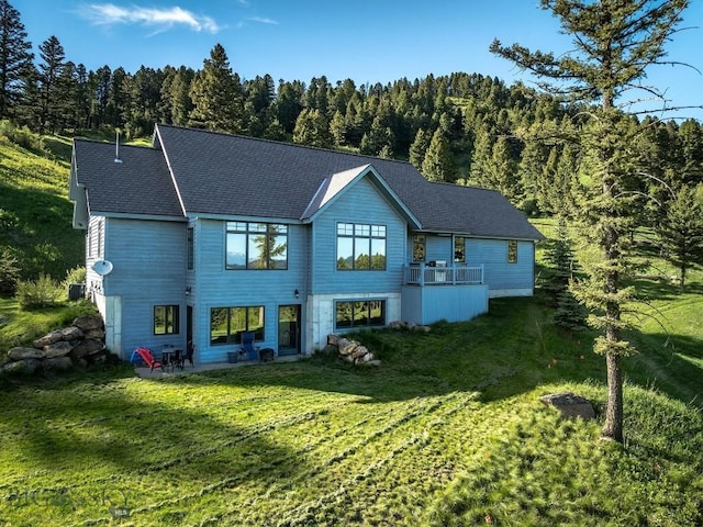 1220 Green Valley Way, Bozeman, MT 59715 - rear view of house featuring a wooded view, a lawn, a patio area, and roof with shingles