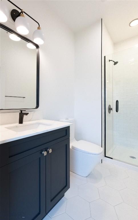 bathroom featuring a shower stall, tile patterned flooring, vanity, and toilet