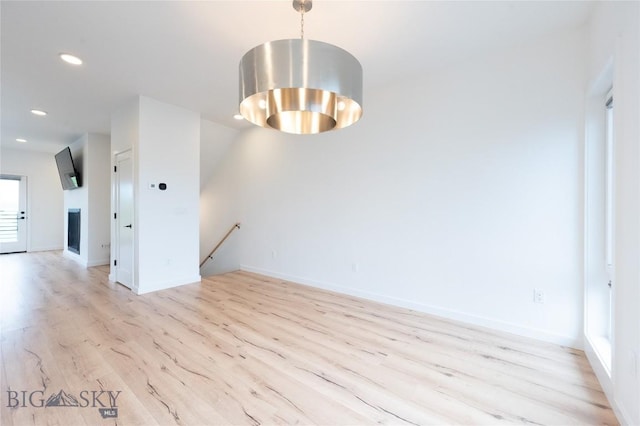 empty room featuring light wood-type flooring, recessed lighting, and baseboards