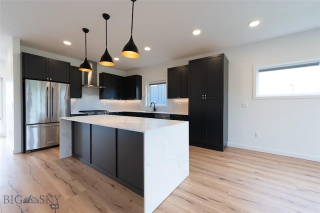 kitchen featuring stainless steel fridge, a kitchen island, light countertops, light wood-style floors, and recessed lighting
