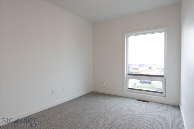 spare room with light carpet and baseboards