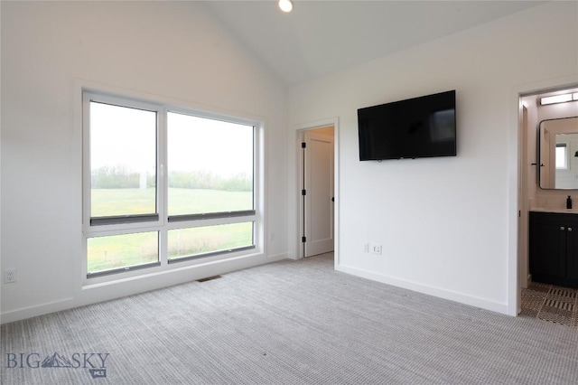 unfurnished room featuring carpet floors, lofted ceiling, and baseboards