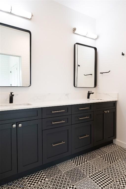 full bath featuring double vanity and baseboards