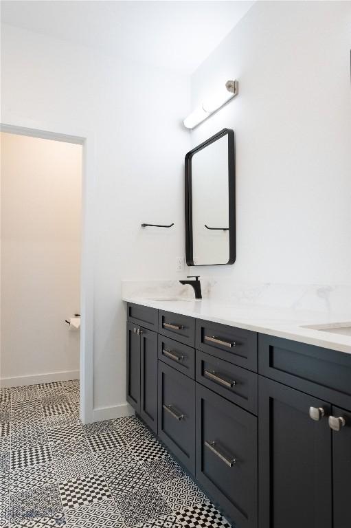 bathroom featuring double vanity and baseboards