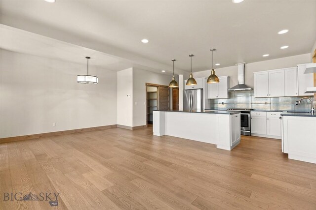 3164 S 15th Ave, Bozeman, MT 59715 - kitchen featuring wall chimney exhaust hood, appliances with stainless steel finishes, dark countertops, recessed lighting, and light wood-type flooring