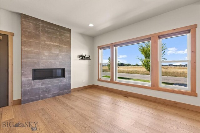 3164 S 15th Ave, Bozeman, MT 59715 - unfurnished living room featuring a tile fireplace, wood finished floors, baseboards, and recessed lighting