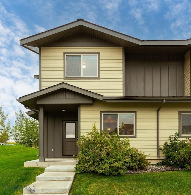view of front of house with board and batten siding and a front lawn