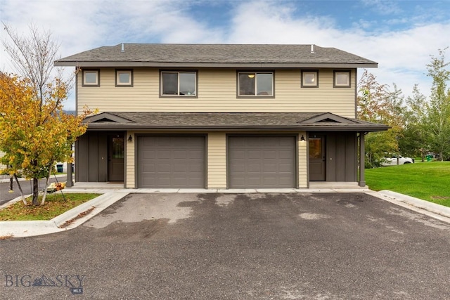 view of front of house with board and batten siding, a garage, driveway, and a front yard