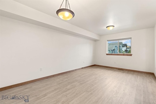 empty room featuring wood finished floors and baseboards