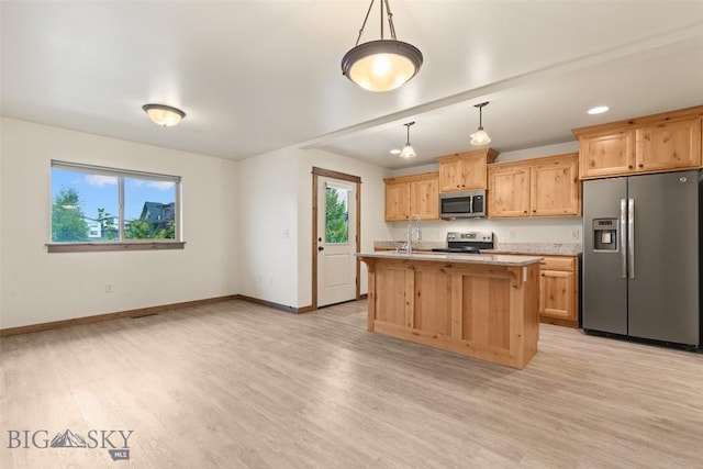 kitchen featuring stainless steel appliances, healthy amount of natural light, baseboards, and light wood-style flooring