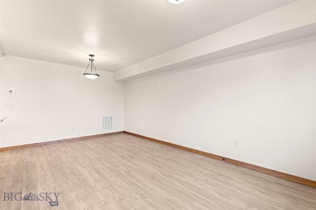 empty room with light wood finished floors and baseboards