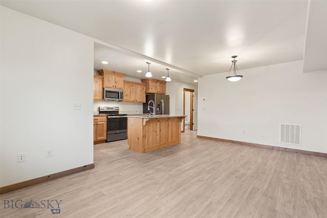 kitchen featuring stainless steel appliances, baseboards, light wood finished floors, light countertops, and a kitchen bar
