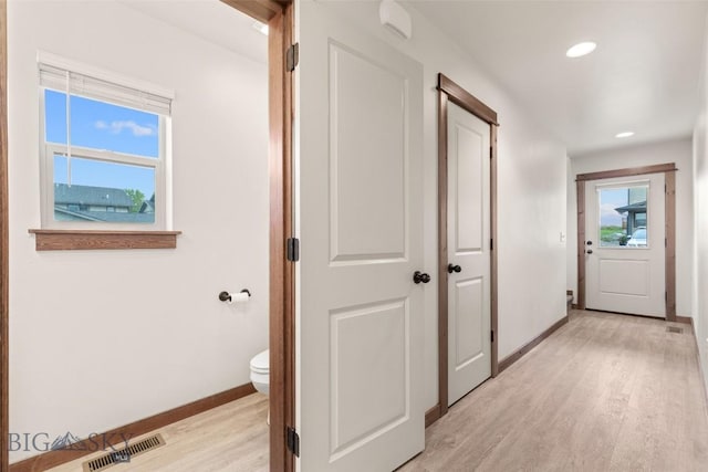 hallway featuring baseboards, light wood-style flooring, and recessed lighting