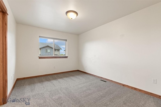 unfurnished room with carpet and baseboards
