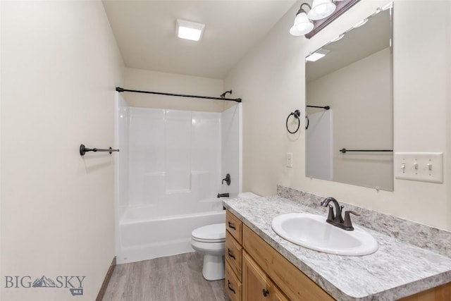 bathroom featuring wood finished floors, toilet, vanity, and shower / bath combination