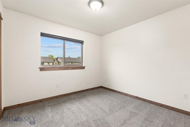 empty room featuring carpet floors and baseboards