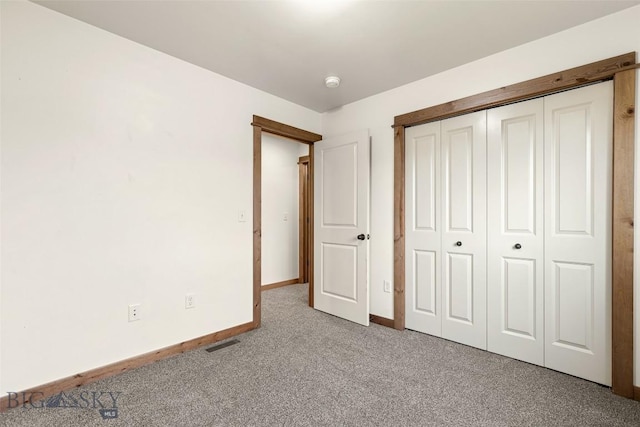 unfurnished bedroom with carpet floors, baseboards, and a closet