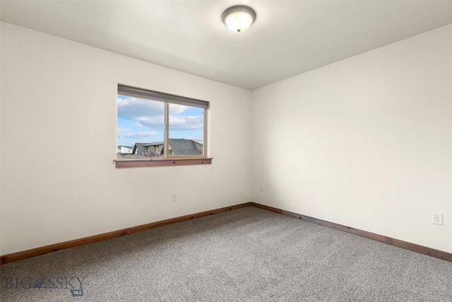 carpeted empty room featuring baseboards