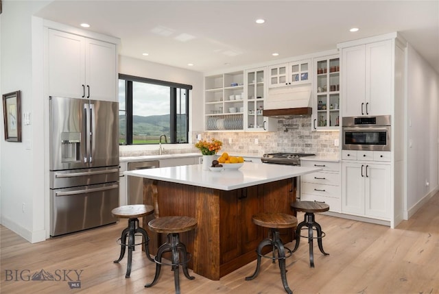 17450 Wilson Creek Rd, Gallatin Gateway, MT 59730 - kitchen with stainless steel appliances, white cabinetry, a kitchen breakfast bar, and recessed lighting