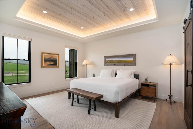 17450 Wilson Creek Rd, Gallatin Gateway, MT 59730 - bedroom featuring a raised ceiling, a barn door, recessed lighting, wood finished floors, and wooden ceiling