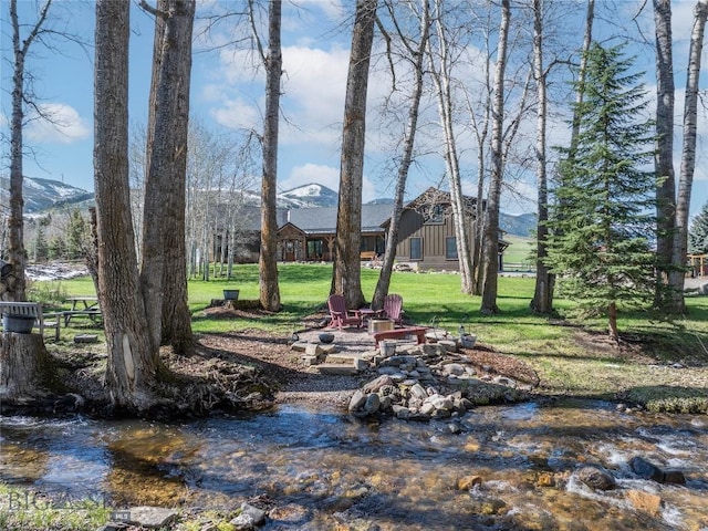 17450 Wilson Creek Rd, Gallatin Gateway, MT 59730 - view of grassy yard featuring a fire pit and a mountain view