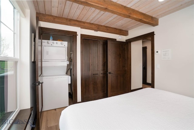 17450 Wilson Creek Rd, Gallatin Gateway, MT 59730 - bedroom featuring estacked washer and dryer, light wood-style floors, a wooden ceiling with exposed beams, and a closet