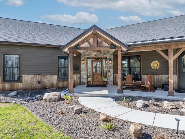 17450 Wilson Creek Rd, Gallatin Gateway, MT 59730 - entrance to property featuring covered porch, roof with shingles, and stone siding