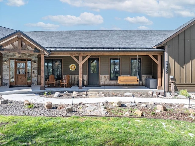17450 Wilson Creek Rd, Gallatin Gateway, MT 59730 - back of house with covered porch, board and batten siding, roof with shingles, and stone siding