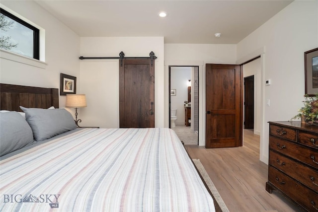 17450 Wilson Creek Rd, Gallatin Gateway, MT 59730 - bedroom with light wood finished floors, a barn door, recessed lighting, and ensuite bath