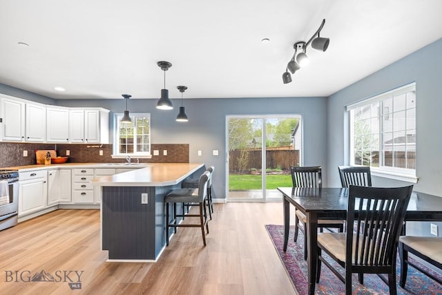 185 Chestnut Grove Ave, Bozeman, MT 59718 - kitchen featuring white cabinetry, light wood-style flooring, plenty of natural light, a peninsula, and recessed lighting