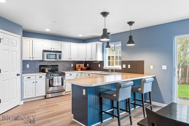 185 Chestnut Grove Ave, Bozeman, MT 59718 - kitchen featuring appliances with stainless steel finishes, a sink, white cabinetry, a peninsula, and recessed lighting