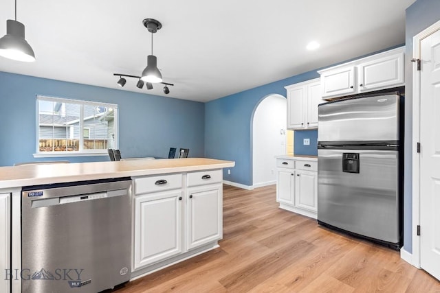 185 Chestnut Grove Ave, Bozeman, MT 59718 - kitchen featuring appliances with stainless steel finishes, arched walkways, light countertops, and light wood-type flooring