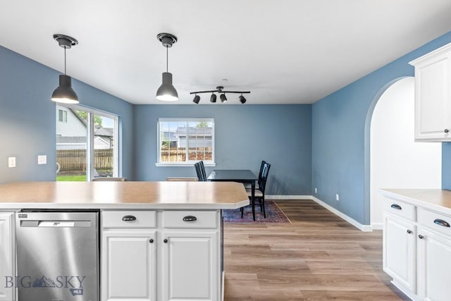 185 Chestnut Grove Ave, Bozeman, MT 59718 - kitchen featuring dishwasher, arched walkways, light countertops, light wood-style floors, and white cabinetry