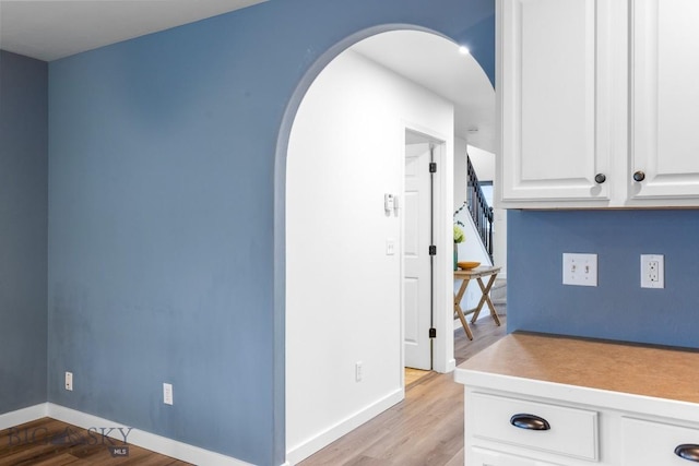 185 Chestnut Grove Ave, Bozeman, MT 59718 - kitchen with arched walkways, wood finished floors, white cabinets, baseboards, and light countertops