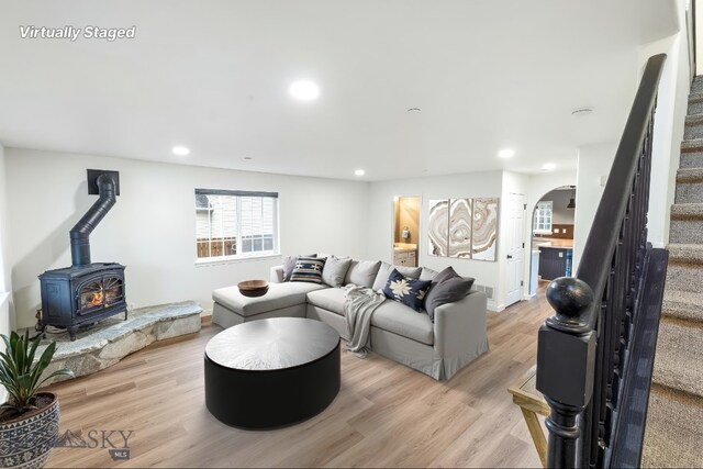 185 Chestnut Grove Ave, Bozeman, MT 59718 - living area featuring arched walkways, stairs, light wood finished floors, a wood stove, and recessed lighting